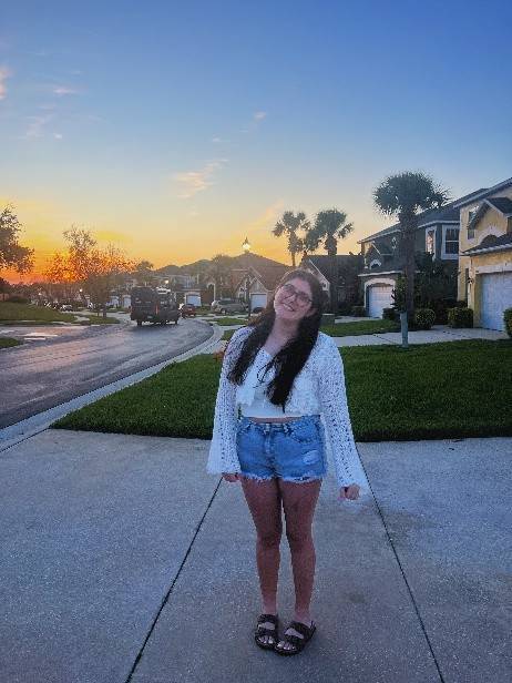 Emma posing with a sunset